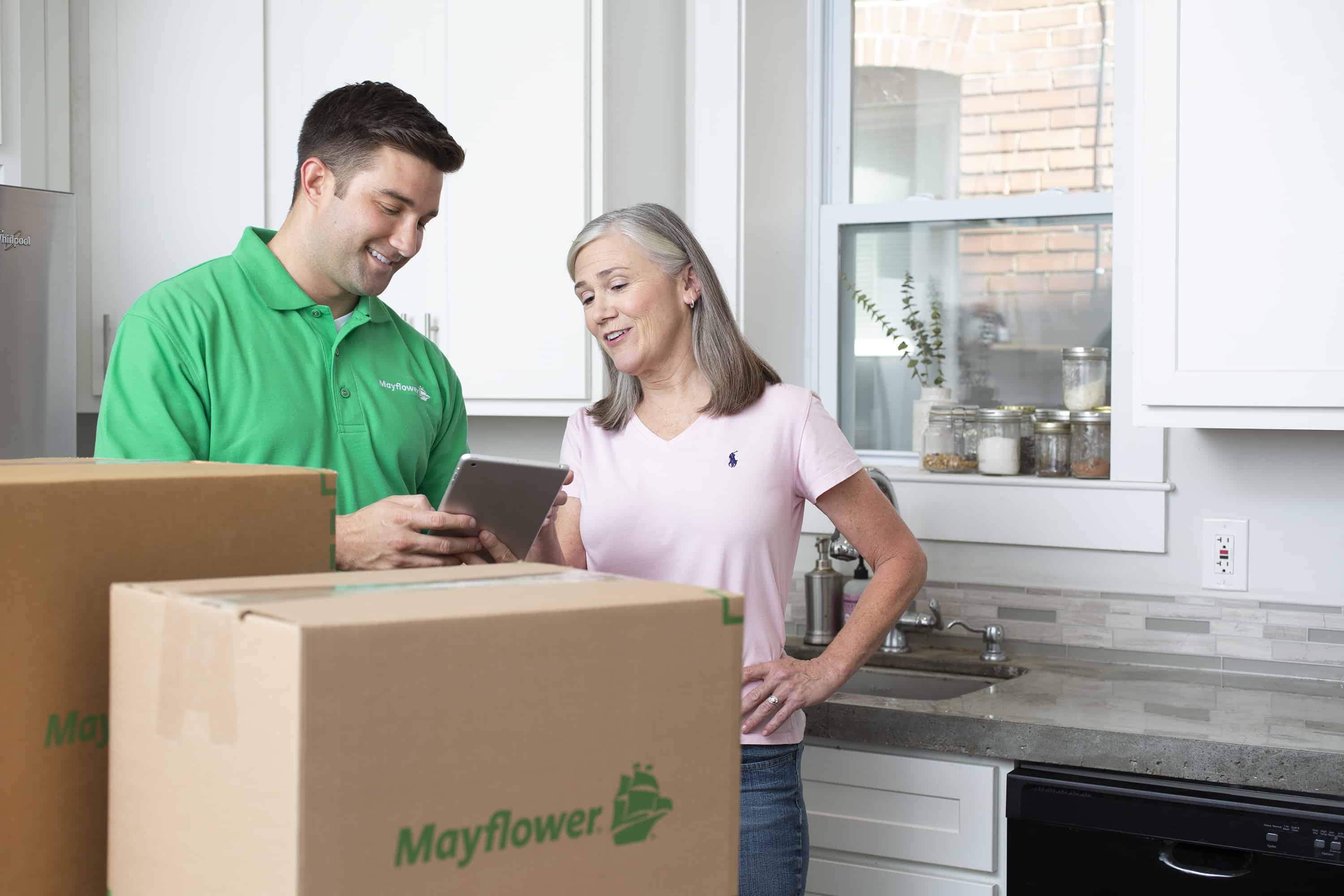 Male mover speaking with female customer in her kitchen - Mayflower®
