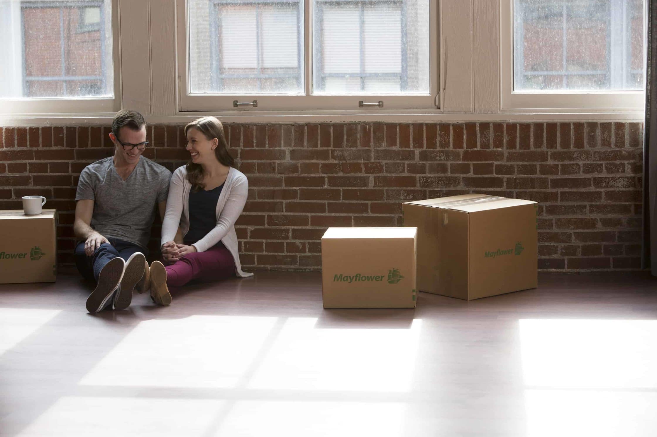 First Night Box - young couple sitting on the floor next to moving boxes - Mayflower