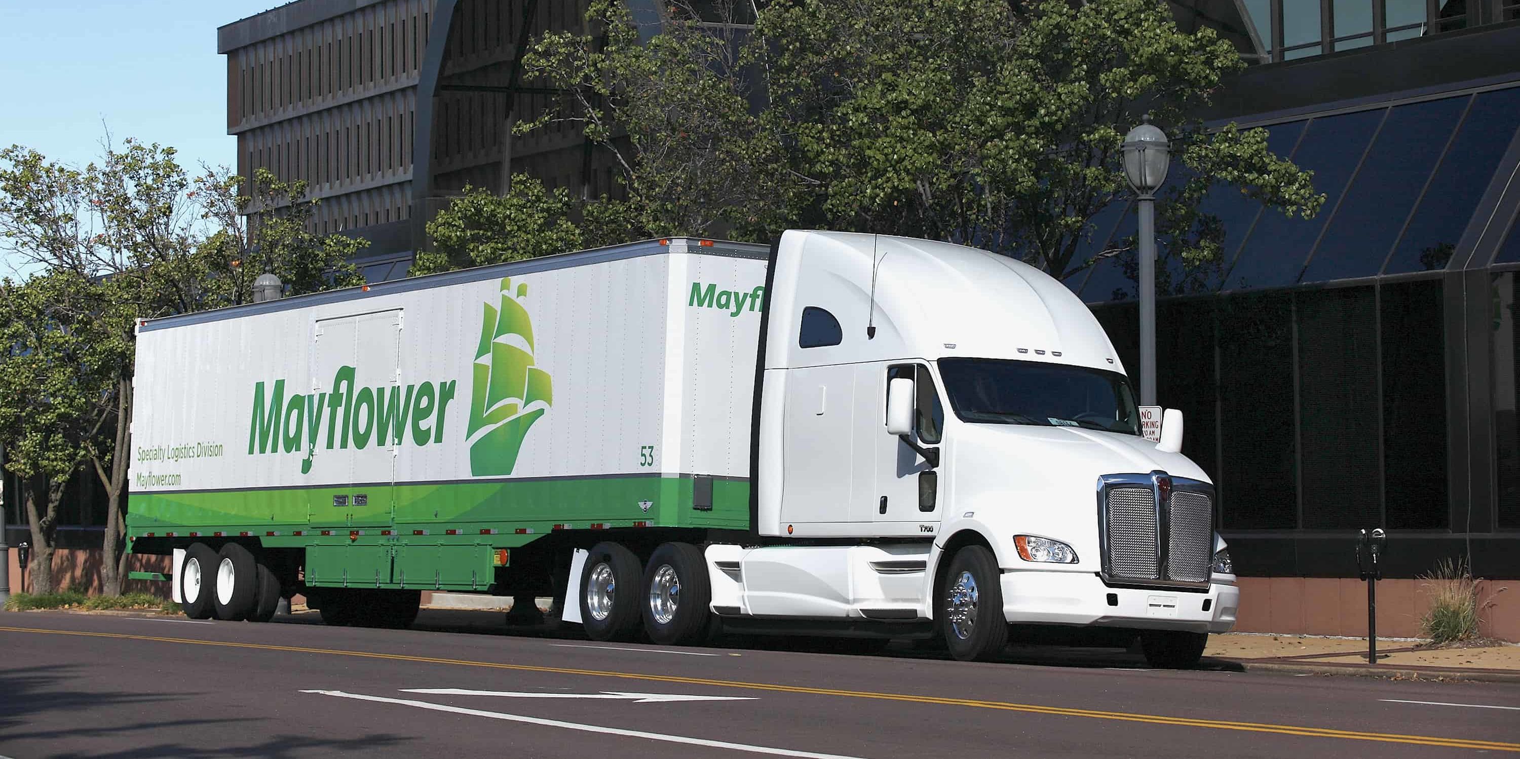 mayflower moving truck driving next to office buildings - Mayflower®