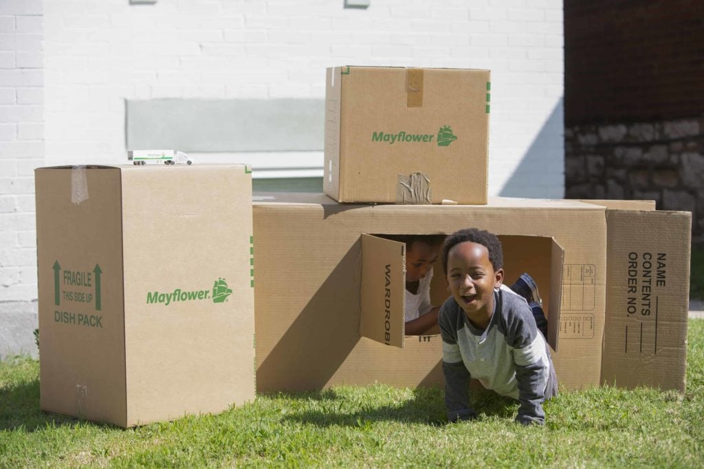 Moving With Kids Is As Easy As 1-2-3 - two little kids in a box fort outside with empty Mayflower moving boxes - Mayflower