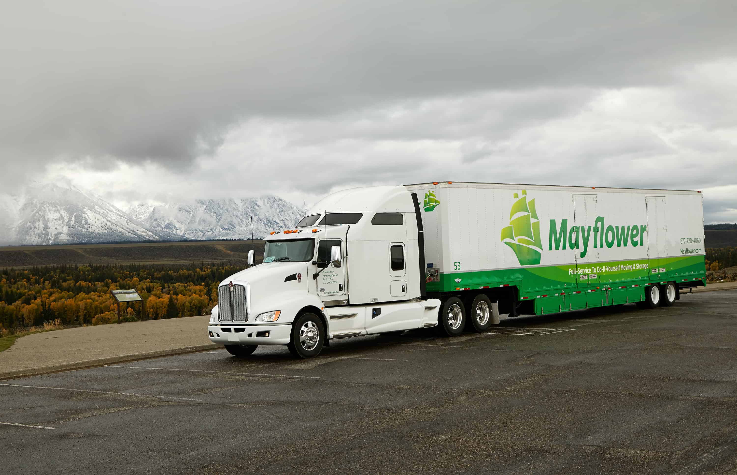 Cross Country Movers - Mayflower moving truck on highway with snowy mountains in the background - Mayflower®