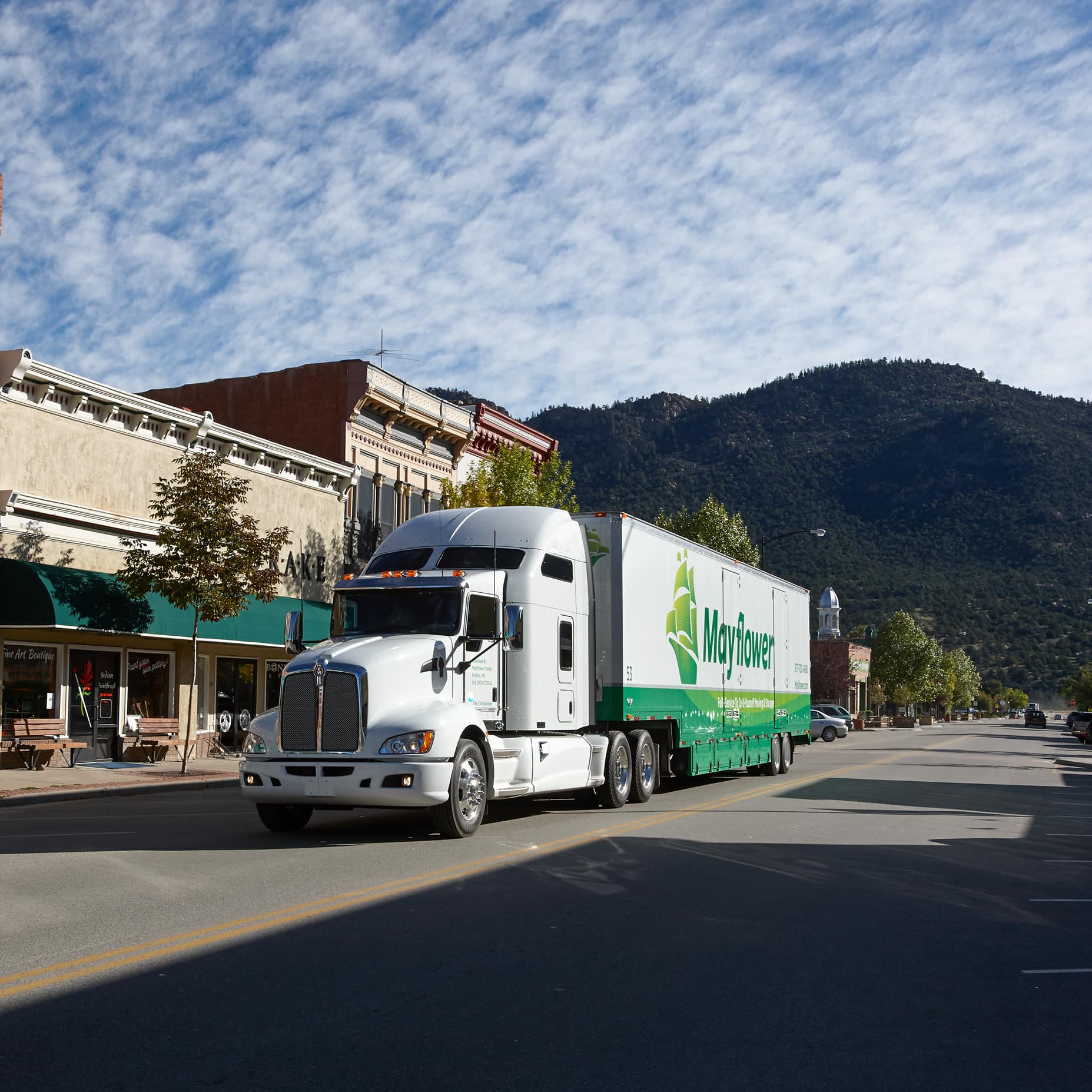Mayflower long distance movers driving through a small mountain town - Mayflower®