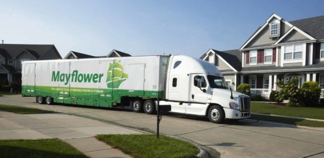 Mayflower moving truck driving through a residential neighborhood - Mayflower®