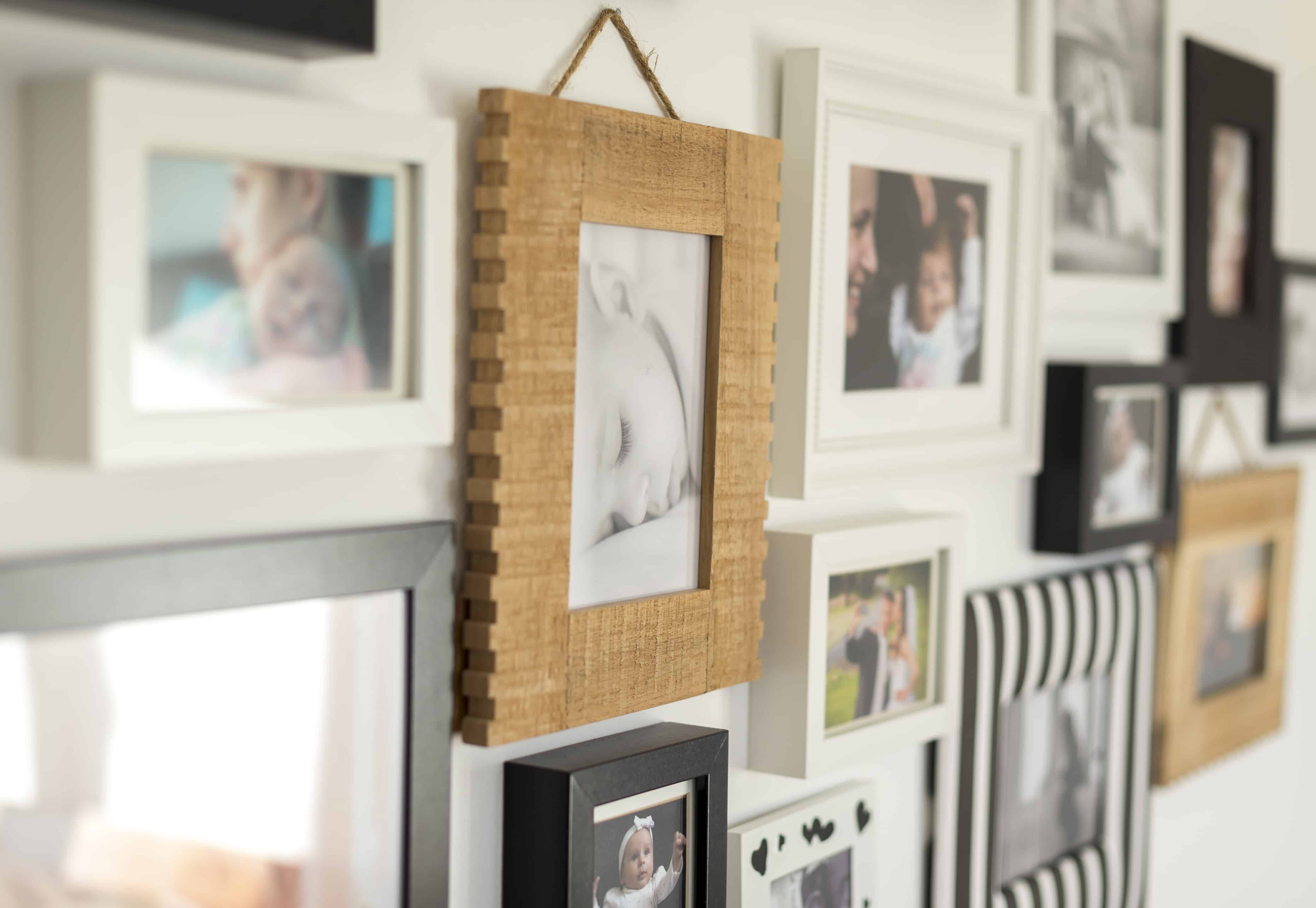 How to Pack a Mirror for Moving - white wall with photos of the family in various photo frames - Mayflower