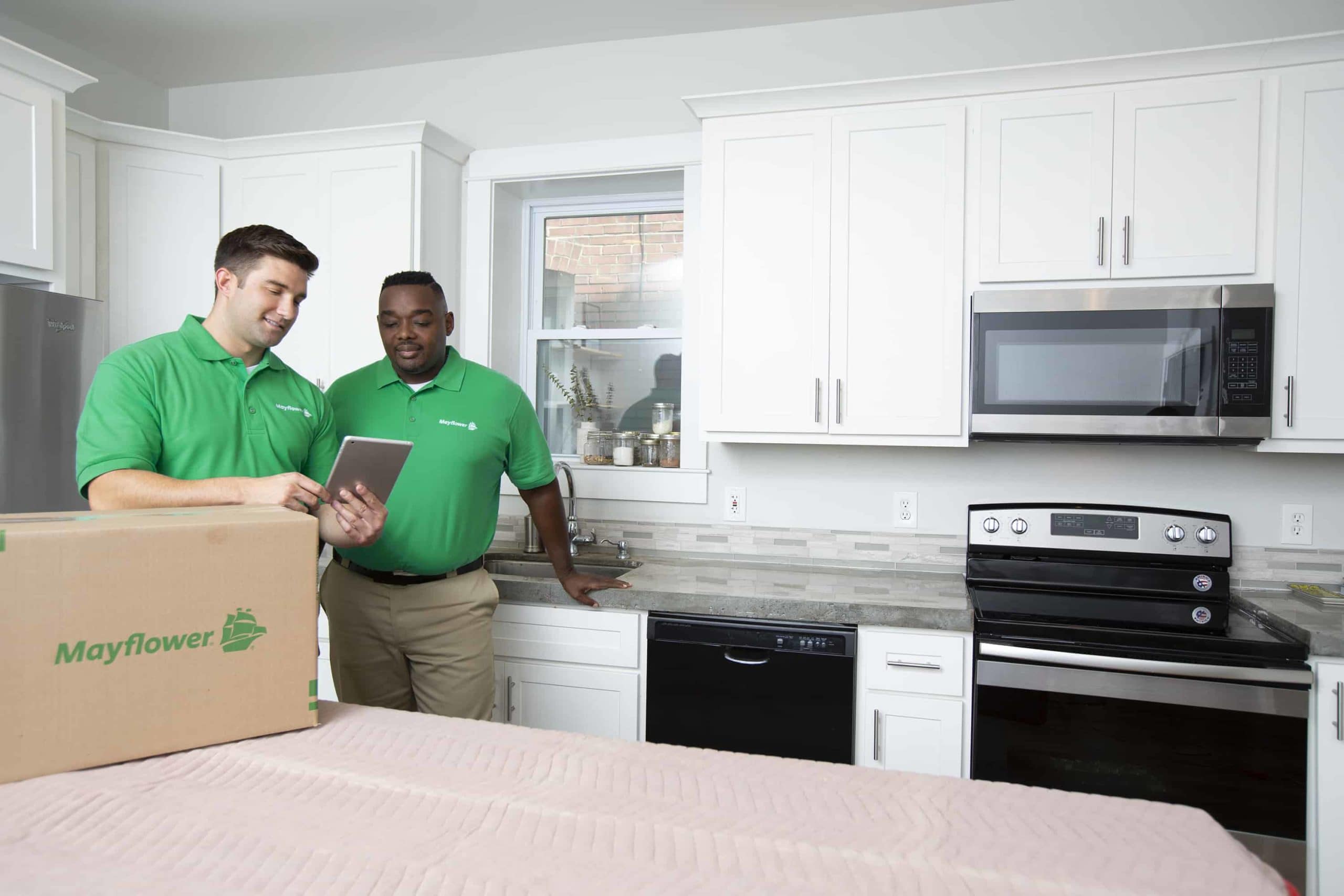 Plan Your Move In Day - two mayflower movers standing in a kitchen reviewing a checklist - Mayflower