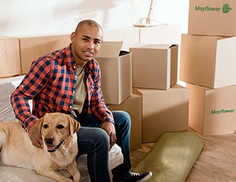 african american man with labrador dog in new apartment with cardboard boxes - Mayflower®