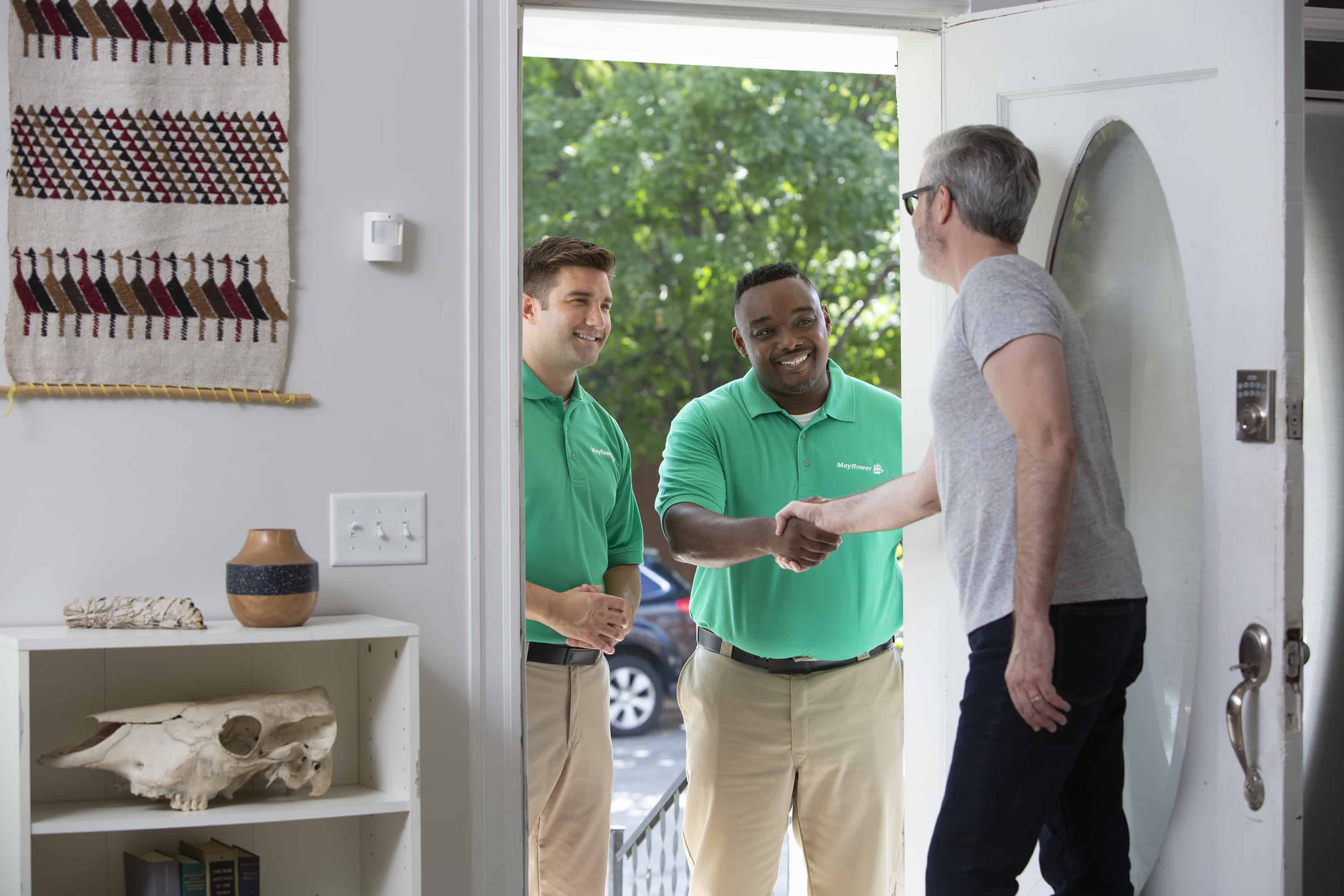 Know Your Moving Rights - two Mayflower movers interacting with a customer in his doorway - Mayflower