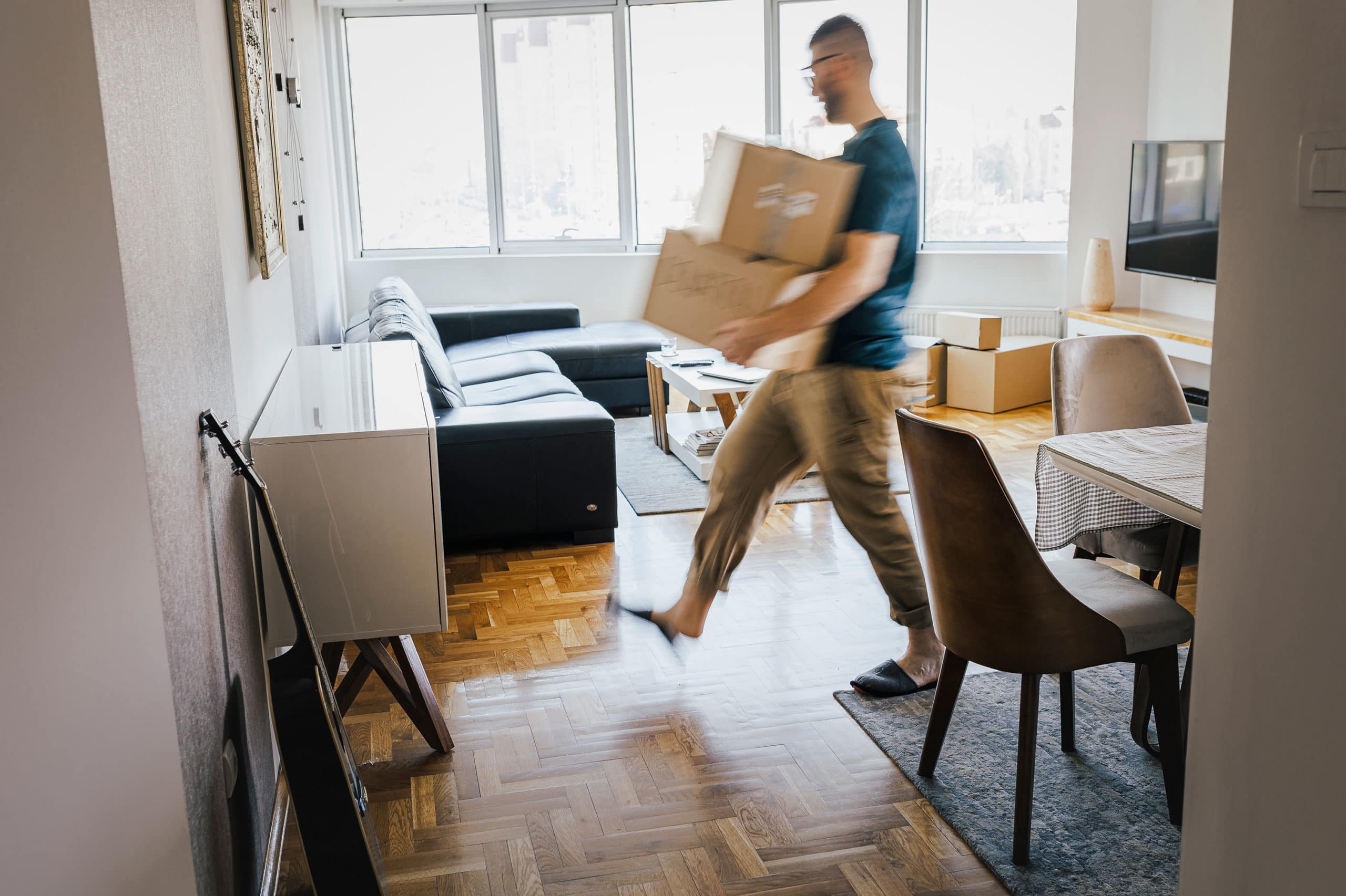 Man moving boxes in living room